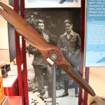 wooden airplane propellor in glass cabinet