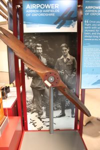 wooden airplane propellor in glass cabinet