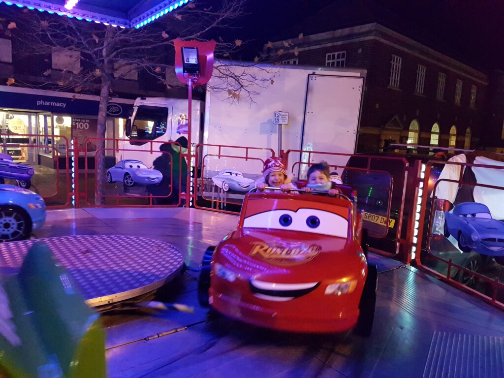kids riding lightening mcqueen at the street fair
