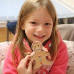Girl holding her gingerbread man ornament