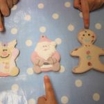 finished ornaments lined up on the table with kids pointing to them