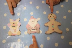 finished ornaments lined up on the table with kids pointing to them