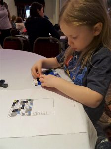 Girl building her lego mosaic