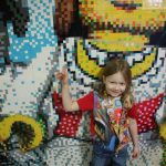 lois standing in front of the legoland hotel wall mosaic