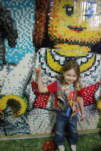 lois standing in front of the legoland hotel wall mosaic
