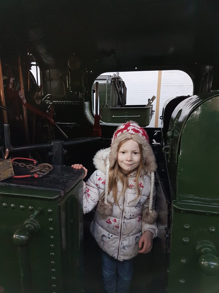 lois stood in drivers cab of steam train