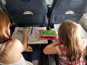 Girls doing colouring books on plane