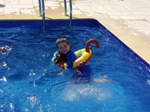 boy wearing inflatable ring to learn to swim