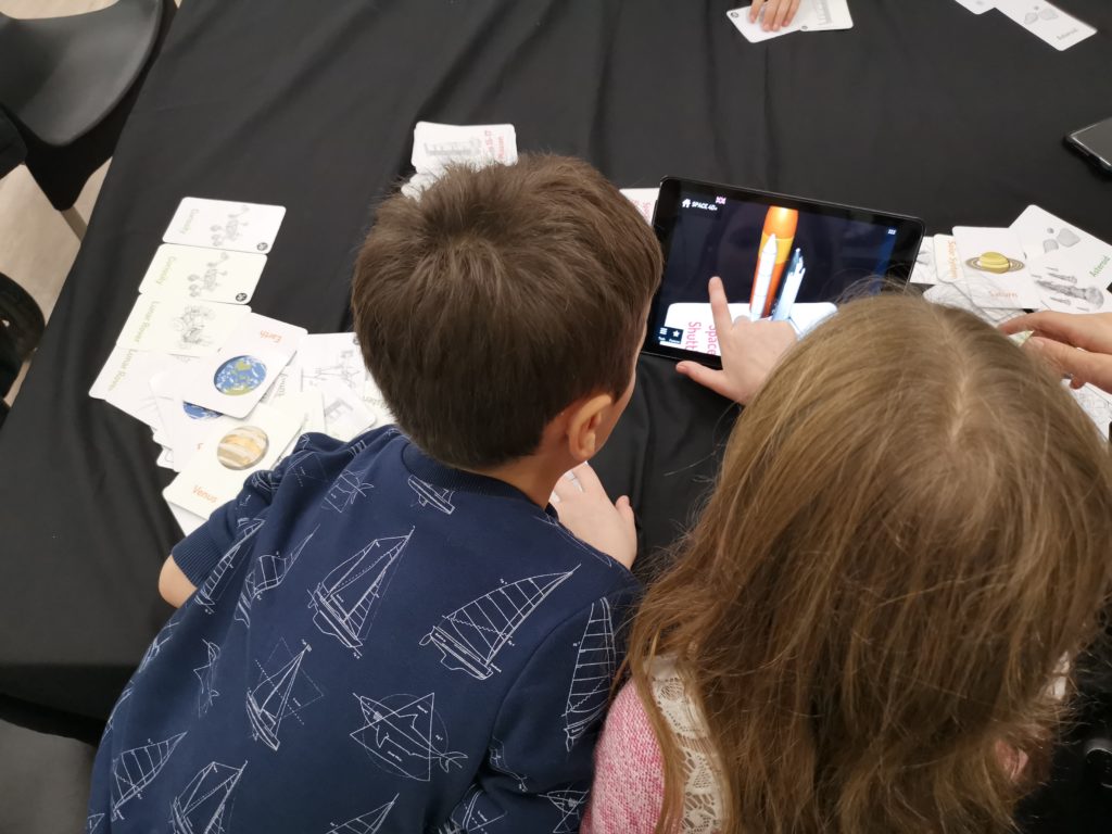 kids using the interactive cards and app on the ipads at the space store