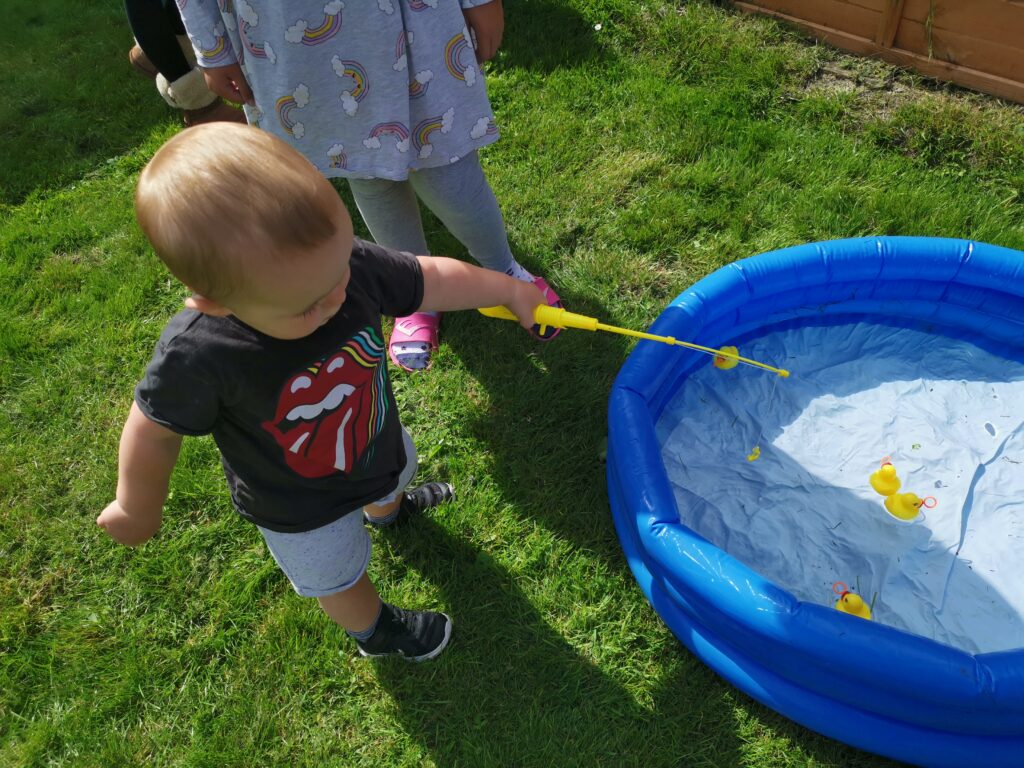 toddler playing hook a duck