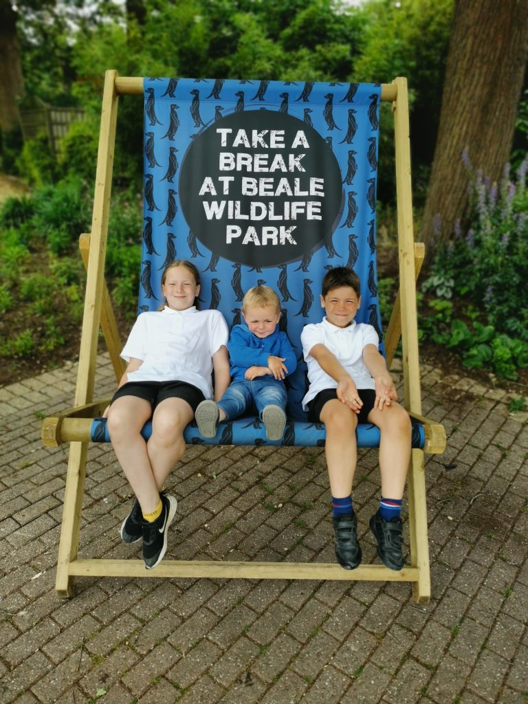3 children sat on giant deck chair at Beale Park