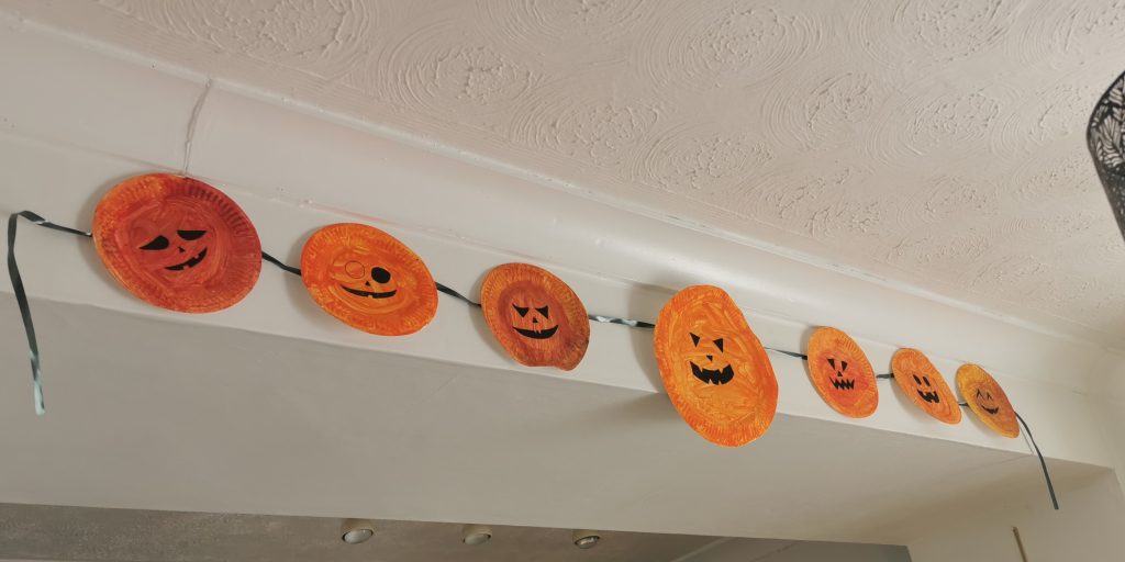 Paper plates painted orange to look like pumpkins and made into bunting