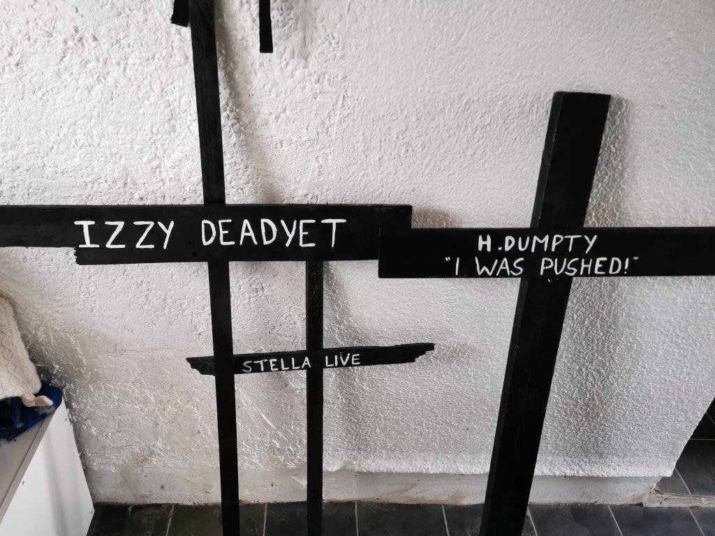 Three wooden handmade crosses with white writing on for Halloween