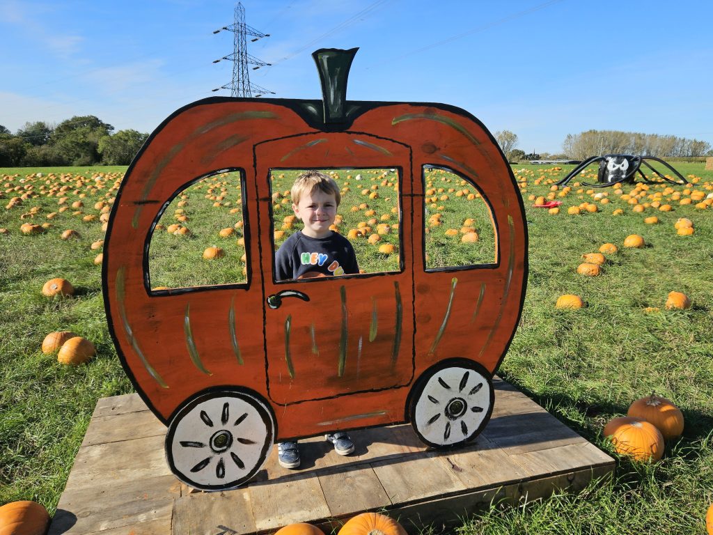 Pumpkin carriage with child stood inside at High Lodge Farm Halloween event