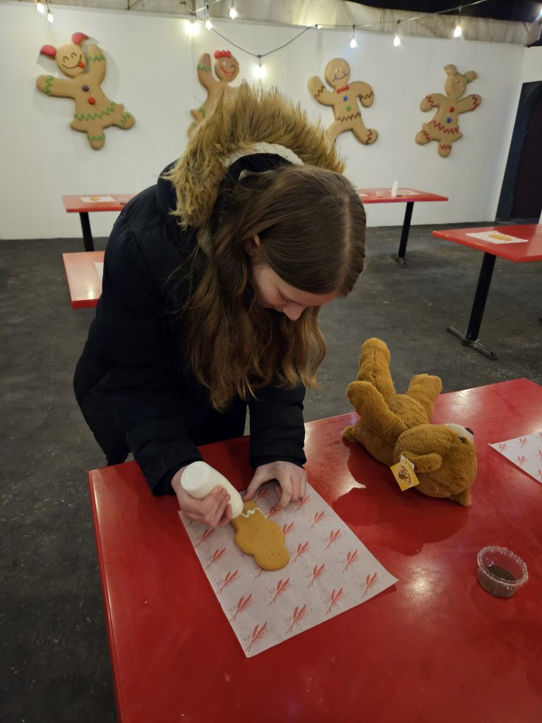 Girl decorating gingerbread man biscuit