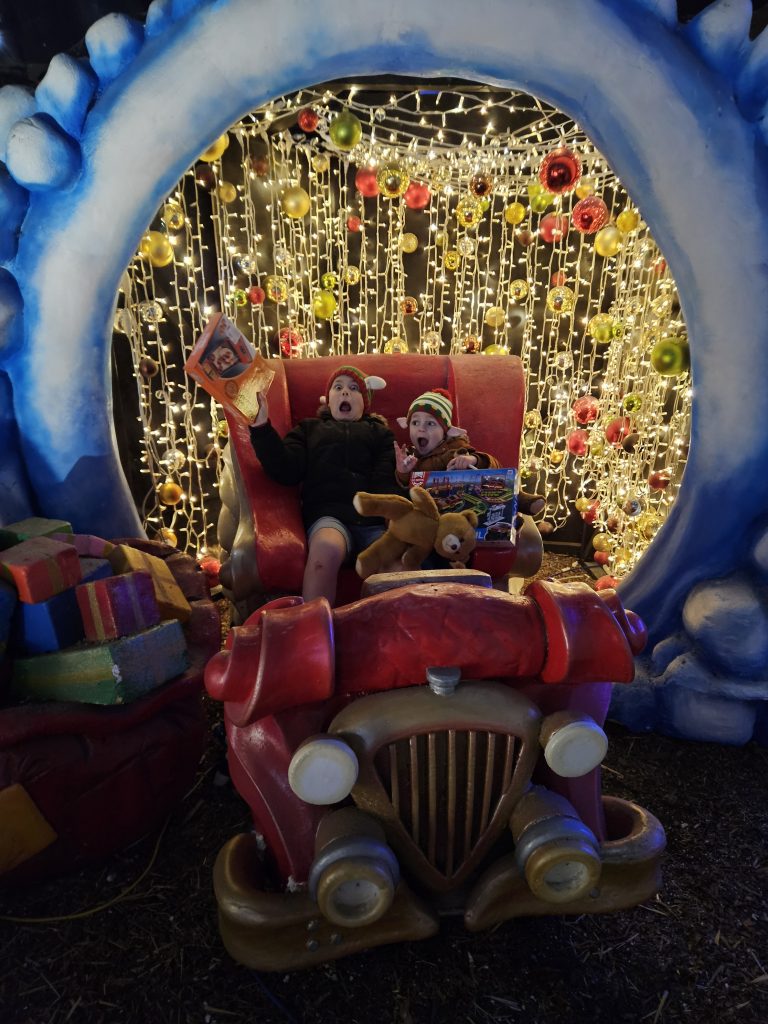 Two boys sat in car with lights behind