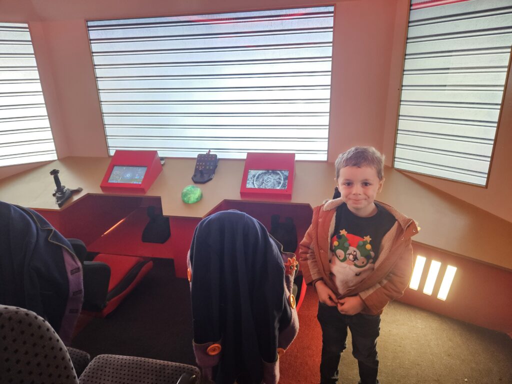 Child stood in front of spaceship control panel