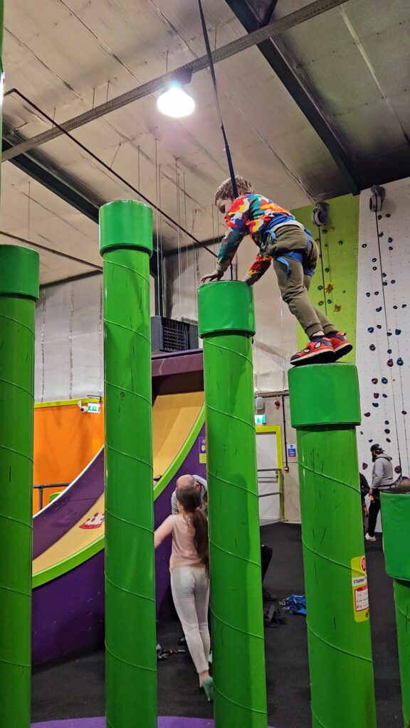 Stairway to Heaven climbing challenge at Clip n Climb Reading. Tall green pillars.